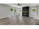 Sunlit living room with a fireplace, large windows, and wood-look flooring creating a warm and inviting space at 19570 Forsythe Dr, Noblesville, IN 46060