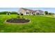 Beautifully landscaped front yard with lush green grass, a decorative flower bed, and exterior lighting at 204 Oakview Dr, Mooresville, IN 46158