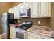 Kitchen featuring stainless steel appliances, light cabinets, and granite countertops at 204 Oakview Dr, Mooresville, IN 46158