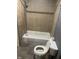 Bathroom featuring toilet, tub with shower head, and tiled walls at 2146 Gent Ave, Indianapolis, IN 46202