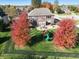 Aerial view of a beautiful brick home with a large backyard, patio, and vibrant autumn foliage at 2219 Stone Manor Ct, Avon, IN 46123