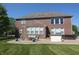 Lush backyard featuring a brick home, patio, fire pit, and well-maintained lawn at 2219 Stone Manor Ct, Avon, IN 46123