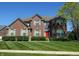 A two-story brick home with shutters, a red front door, and a manicured lawn at 2219 Stone Manor Ct, Avon, IN 46123