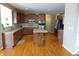 Open kitchen featuring wood cabinets, a granite island, stainless steel appliances, and hardwood flooring at 2219 Stone Manor Ct, Avon, IN 46123