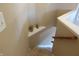 Carpeted staircase with wooden handrail and neutral wall paint, featuring decorative vases on a shelf at 2219 Stone Manor Ct, Avon, IN 46123