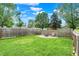 Large backyard featuring a well-maintained lawn, wooden fence, and a cozy fire pit area, perfect for outdoor gatherings at 2303 Midway St, Columbus, IN 47201