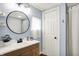 Bathroom featuring a round mirror over the vanity and a white door with a shower curtain at 2303 Midway St, Columbus, IN 47201
