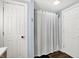 Bathroom featuring a gray and white striped shower curtain and white doors at 2303 Midway St, Columbus, IN 47201