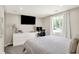 Bedroom features a TV, desk, white dresser, and view to outside from large window at 2303 Midway St, Columbus, IN 47201