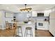 Well-lit kitchen with white appliances, a cozy eating area, and a stylish island with barstool seating at 2303 Midway St, Columbus, IN 47201