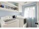 Bright laundry room with modern appliances, overhead storage, and a window, offering a functional and inviting space at 2303 Midway St, Columbus, IN 47201