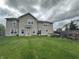 Large backyard with a two-story home, lush lawn, and a stone fire pit ready for relaxation and entertainment at 2680 Newington Ln, Carmel, IN 46074