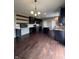 Open-concept kitchen featuring dark cabinets, stainless steel appliances, island and wood floors at 2680 Newington Ln, Carmel, IN 46074