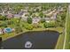 Aerial view of a serene community pond near a beautiful home with a well-manicured lawn at 28 Hudson Bay Ln, Greenwood, IN 46142