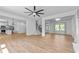 Bright, open-concept living room with modern fan, wood floors, and seamless flow to the kitchen and entry at 28 Hudson Bay Ln, Greenwood, IN 46142