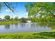 Scenic community pond featuring a fountain and lush landscaping under a bright blue sky at 28 Hudson Bay Ln, Greenwood, IN 46142