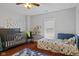 Charming bedroom featuring a crib, twin bed, playful decor and hardwood floors at 2919 Macpherson Ave, Indianapolis, IN 46205