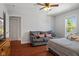 Bright bedroom features a full-sized bed and small couch. Ceiling fan and hard wood floors add charm at 2919 Macpherson Ave, Indianapolis, IN 46205