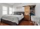 Bedroom features a queen-sized bed, barn door closet, and hardwood floors at 2919 Macpherson Ave, Indianapolis, IN 46205