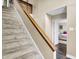Bright stairway featuring neutral walls, soft carpet, and a wooden handrail, leading to the upper level at 3002 Horse Hill W Dr, Indianapolis, IN 46214