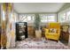 Cozy sun room with a stone accent wall, patterned rug, and bright yellow chair at 3002 Horse Hill W Dr, Indianapolis, IN 46214