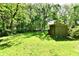 A spacious backyard with green grass, mature trees, and a small storage shed at 3021 Eastern Ave, Indianapolis, IN 46218