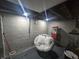 A basement area with a chair and a popcorn machine against the background of grey walls at 3021 Eastern Ave, Indianapolis, IN 46218
