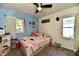 A cozy bedroom with a ceiling fan and a comfortable bed with many cute decorations at 3021 Eastern Ave, Indianapolis, IN 46218