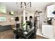 Dining room features black table and pendant lighting near the white kitchen at 3021 Eastern Ave, Indianapolis, IN 46218