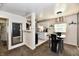 Open-concept dining room featuring a glass table, modern light fixture, and view into the kitchen at 3021 Eastern Ave, Indianapolis, IN 46218