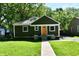 Traditional one-story house with a green facade, and a walkway to the bright orange front door at 3021 Eastern Ave, Indianapolis, IN 46218