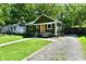Charming one-story home with a green exterior, orange door, and well-maintained lawn at 3021 Eastern Ave, Indianapolis, IN 46218