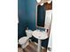 Powder room featuring a pedestal sink, gold accents, and dark blue walls at 3110 W New York St, Indianapolis, IN 46222