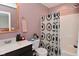 Bright bathroom features vanity with white countertop and shower with decorative curtain at 3110 W New York St, Indianapolis, IN 46222