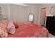 Bedroom with a plush coral bedspread, side table and closet at 3110 W New York St, Indianapolis, IN 46222