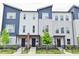 Attractive townhomes with blue and gray siding, black doors, and well-manicured landscaping at 3110 W New York St, Indianapolis, IN 46222