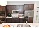 Modern kitchen features stainless steel appliances, dark wood cabinets, and white quartz countertops at 3110 W New York St, Indianapolis, IN 46222