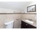 Cozy half bath includes a granite-topped vanity with a dark wood cabinet and tile accents for added style at 3216 N Kenwood Ave, Indianapolis, IN 46208