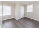 Bright bedroom showcases wood-look flooring, neutral walls, and two windows, creating a cozy, inviting space at 3216 N Kenwood Ave, Indianapolis, IN 46208
