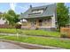 Charming home featuring a covered front porch, green roof, and manicured lawn at 3216 N Kenwood Ave, Indianapolis, IN 46208