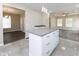 Open-concept kitchen features an island with granite countertops and white cabinets, seamlessly connecting to the living area at 3216 N Kenwood Ave, Indianapolis, IN 46208