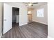 Spacious main bedroom boasts wood-look floors, a ceiling fan, and ensuite access, offering comfort and convenience at 3216 N Kenwood Ave, Indianapolis, IN 46208