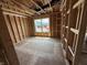 Unfinished room showing exposed wood framing, a window, and a concrete floor, capturing the building phase at 3321 Godby Dr, Sheridan, IN 46069
