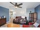 Spacious living room with ceiling fan, wood floors, comfortable brown leather sofa, and accent decor at 3341 Enclave Xing, Greenwood, IN 46143
