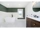 Modern bathroom features soaking tub, dark green accent wall, and stylish wood vanity at 3370 N New Jersey St, Indianapolis, IN 46205