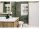 Modern bathroom featuring wood vanity with a tiled shower and green accent wall at 3370 N New Jersey St, Indianapolis, IN 46205