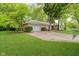 Exterior view of the home and attached garage showing mature trees, well-maintained lawn, and curb appeal at 3698 E 106Th St, Carmel, IN 46033
