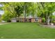 Charming red brick ranch home featuring a spacious green lawn and mature trees at 3698 E 106Th St, Carmel, IN 46033