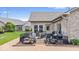 Brick home's backyard shows a patio that includes outdoor furniture, landscaping, and a manicured lawn at 4134 Bella Ct, Indianapolis, IN 46237