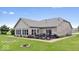 Backyard view of a brick home with a patio, outdoor furniture, a well-manicured lawn, and landscaping at 4134 Bella Ct, Indianapolis, IN 46237